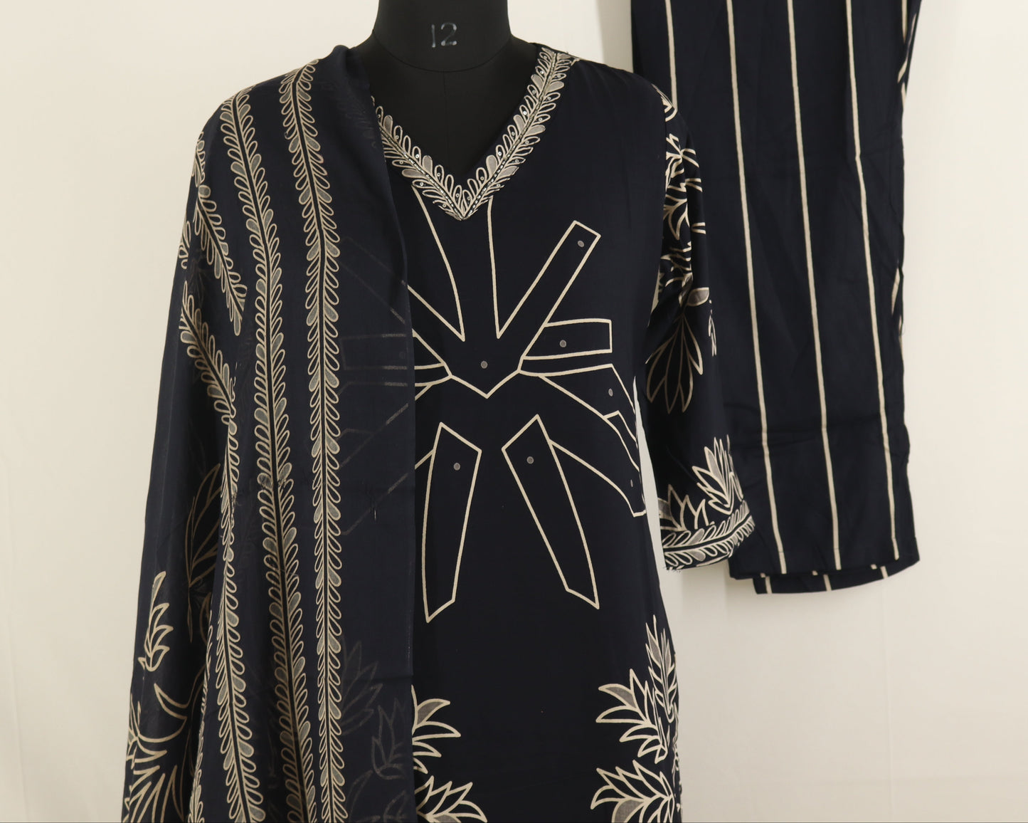 Black and white patterned dress on a mannequin and hanger against a white background