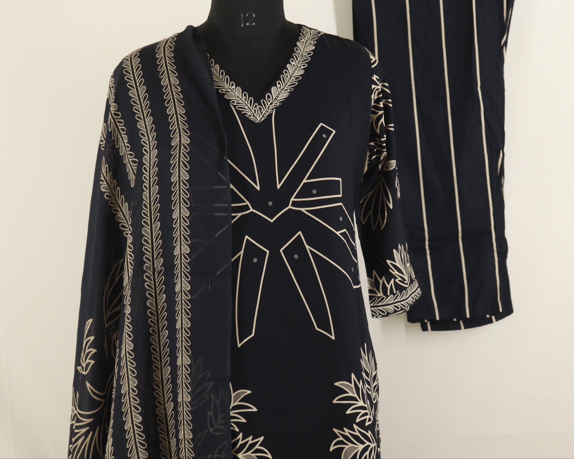 Black and white patterned dress on a mannequin and hanger against a white background